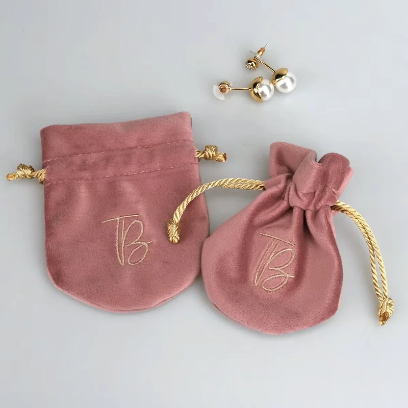 Two rose-colored jewelry pouches shown flat and gathered