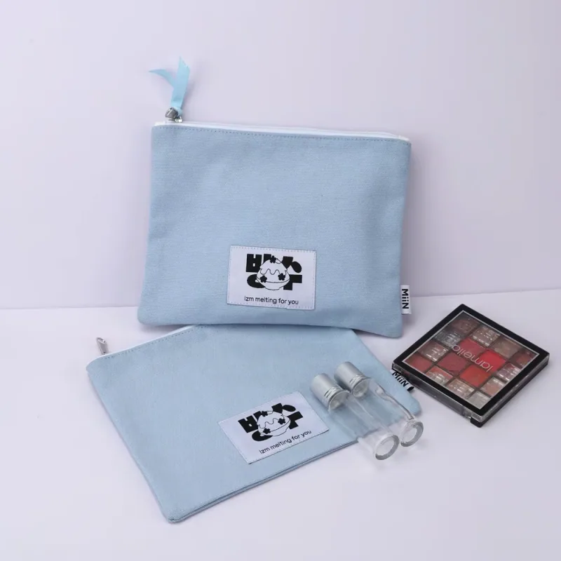 Light blue flat zipper pouches with woven labels