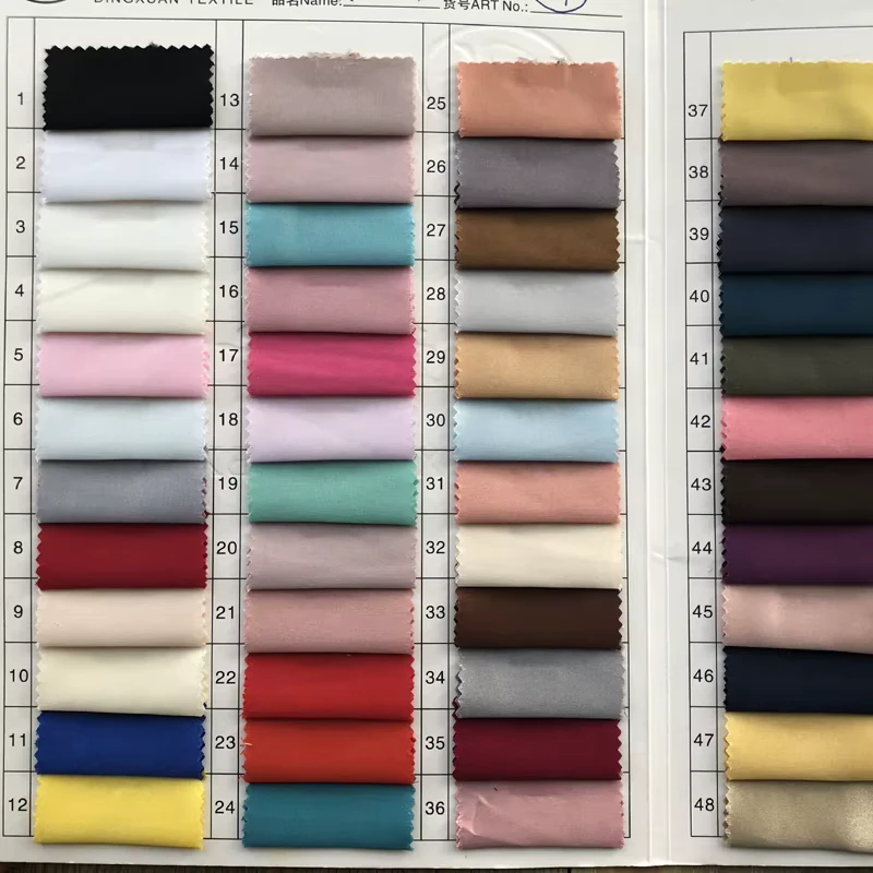 Fabric swatch book with woven material samples in neutral, pastel, and bright colors