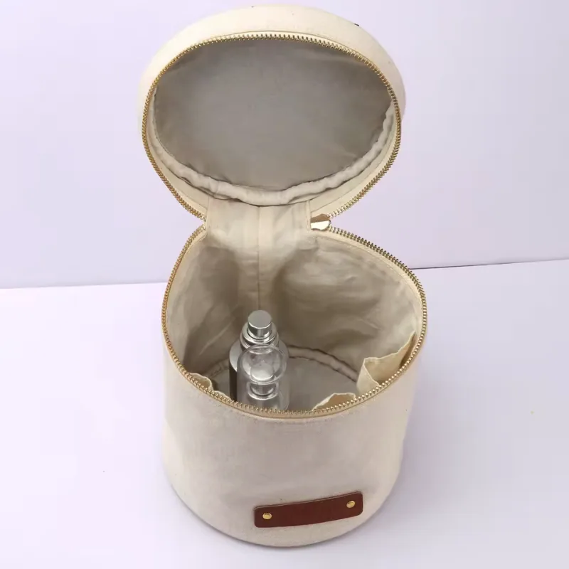 Open cream cylindrical cosmetic case showing inner pockets, lining, and a bottle