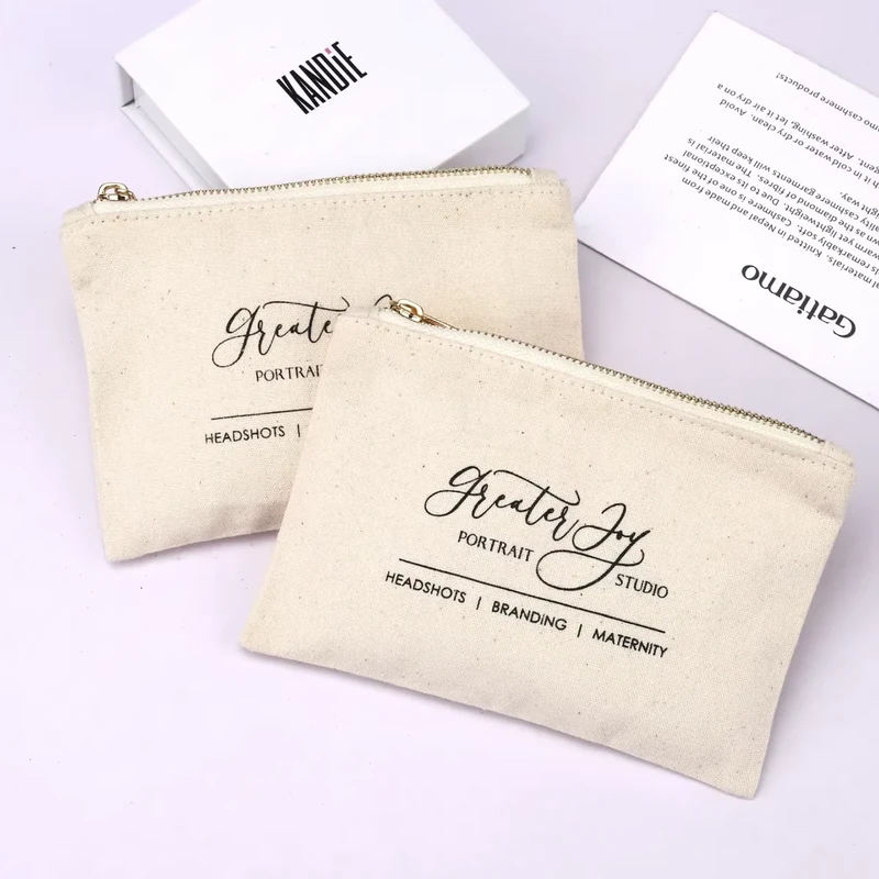 Two finished cream canvas zipper pouches with printed artwork