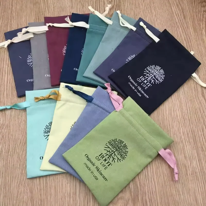 Cotton drawstring pouch samples in multiple fabric colors with contrasting ribbon ties