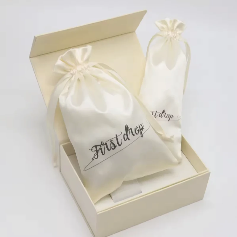 Ivory satin drawstring pouch presented inside a gift box