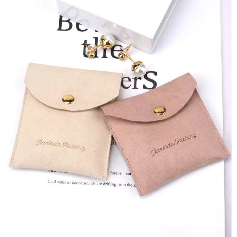 Ivory and blush flap jewelry pouches with snap fastenings