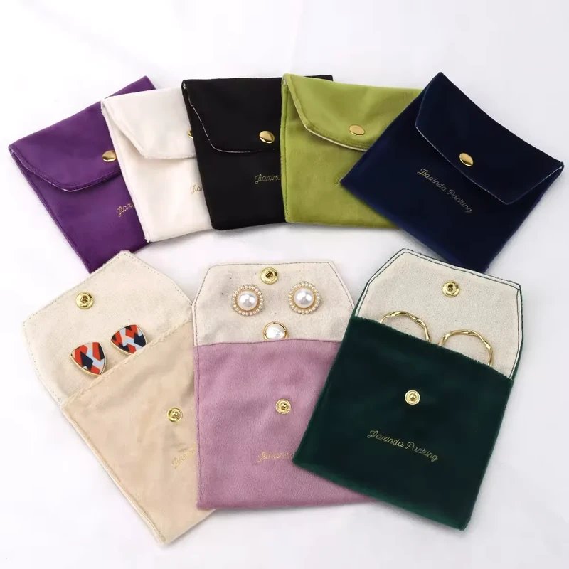 Small flap jewelry pouches in a range of dark and pastel fabric colors
