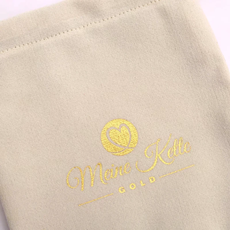 Gold logo printed on an ivory jewelry pouch