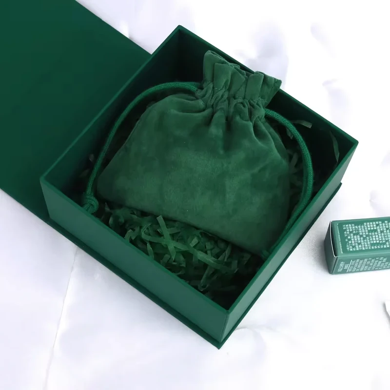 Green drawstring jewelry pouch presented in a matching box