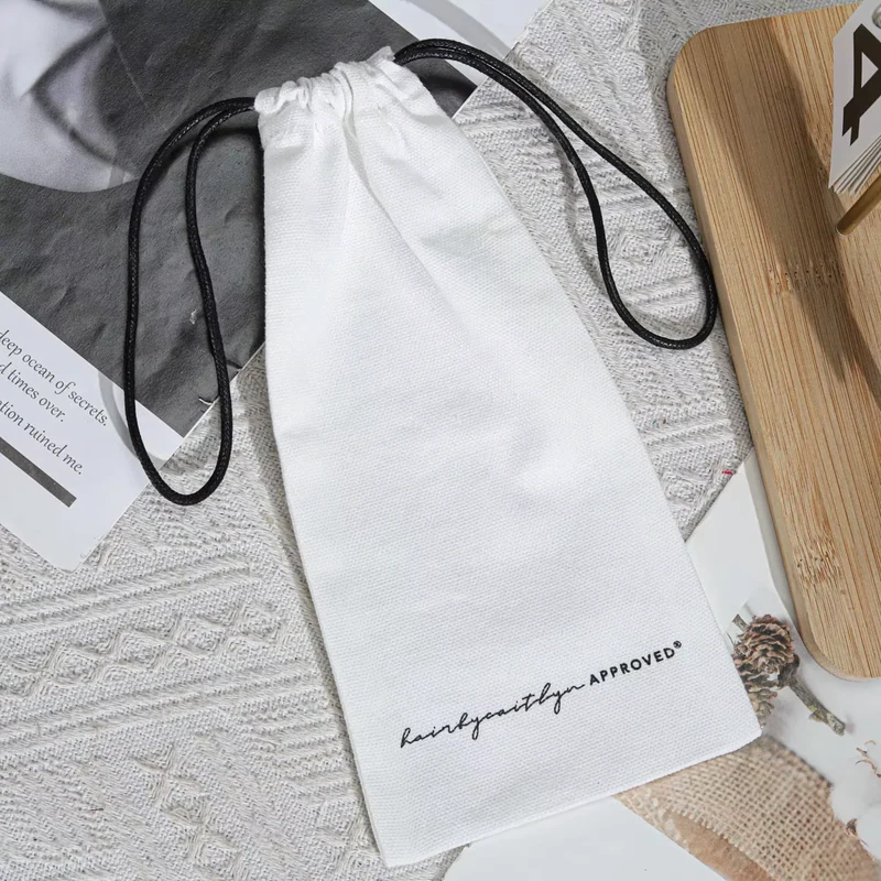 Charcoal and ivory drawstring bags laid flat together.