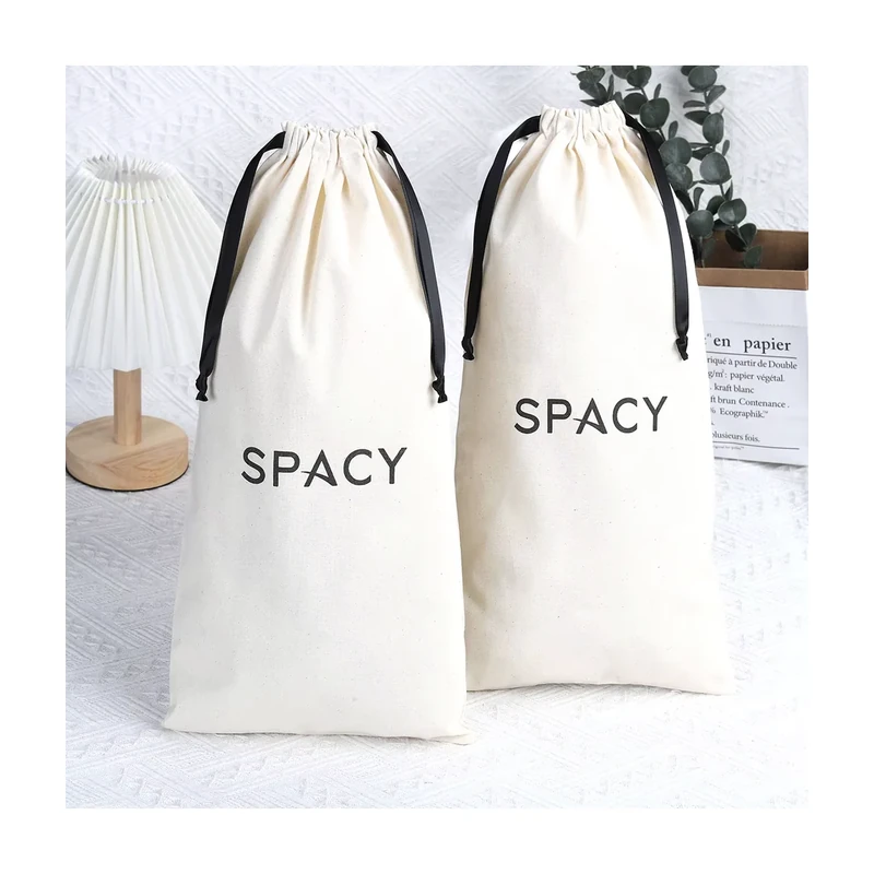 Two tall ivory cotton drawstring bags with black ribbon ties and printed logos