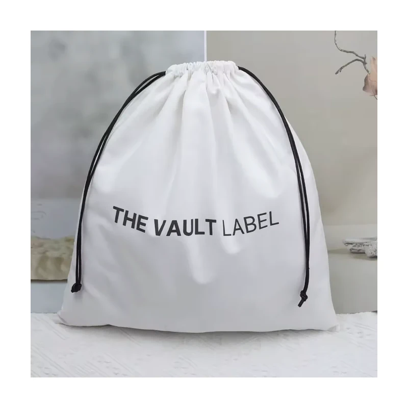 White cotton drawstring storage bag with black ribbon ties and a printed wordmark