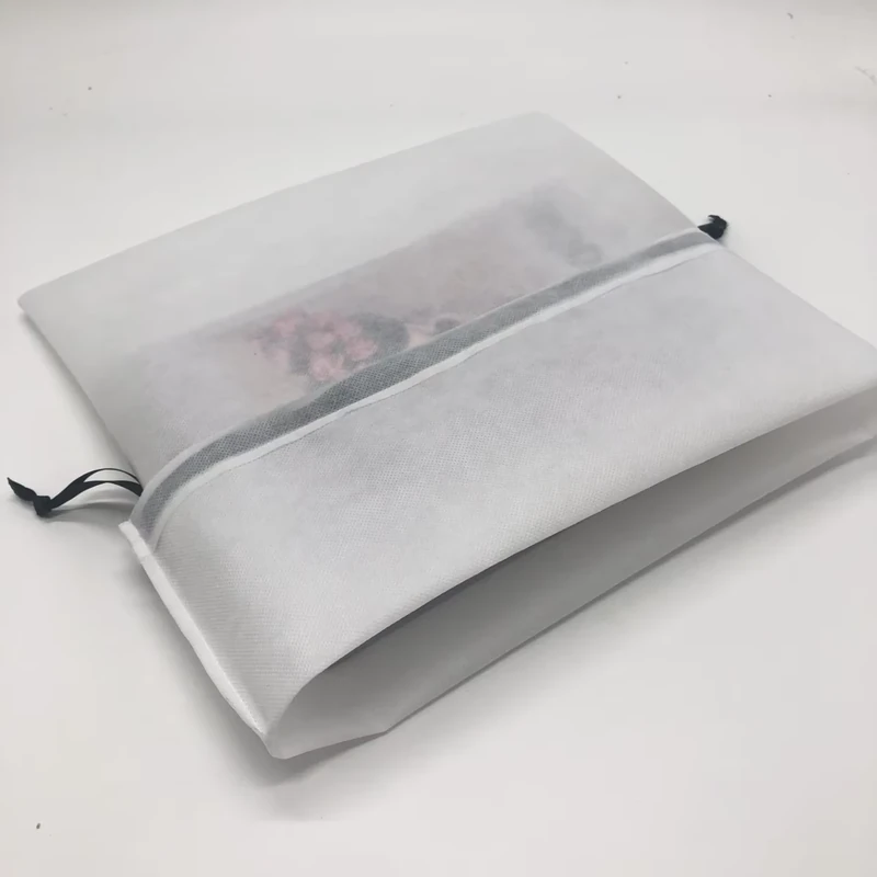 Turned-back opening of a white shoe bag showing the inner fabric and seam