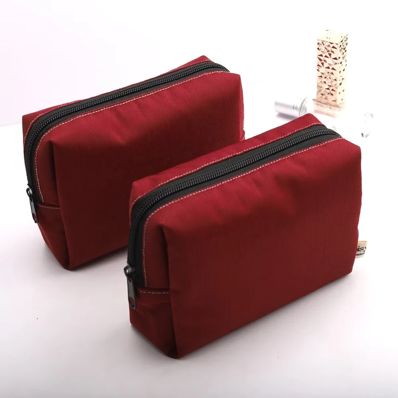 Two red zipper travel pouches with gusseted bodies in different sizes