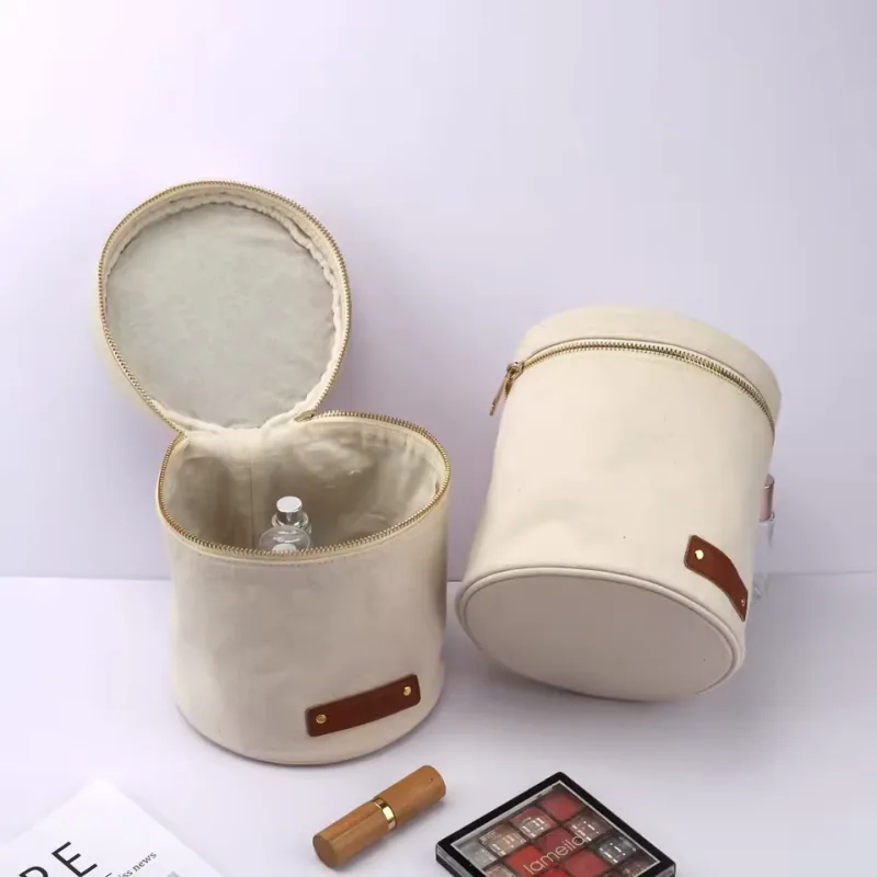 Cream cylindrical travel organizers, one open to show its lined interior