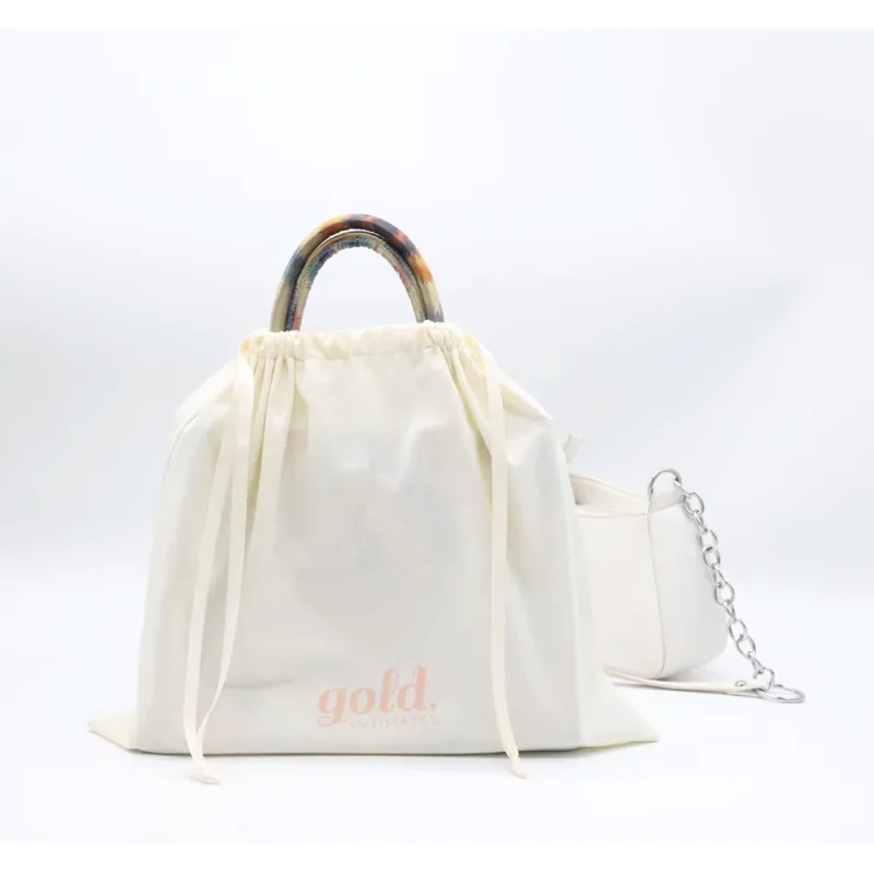 An ivory drawstring dust bag covering a handbag.